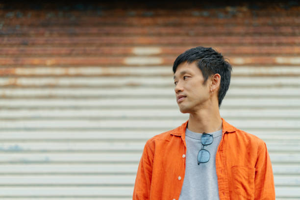 Man standing in front of wall and looking away