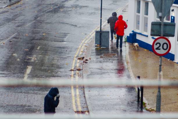 personnes traversant la route dans le temps d’inondation flash extrême à brighton royaume-uni - pedestrian accident england street photos et images de collection