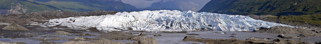 Enormous Matanuska Glacier in the Chugach Mountains at its terminus, Alaska, USA. Terminus is the lower-most margin end of a glacier. Huge amount of rock debris deposited by a glacier in front of terminus is called the moraine; piles of loose unconsolidated rock at the glacier's downvalley end.