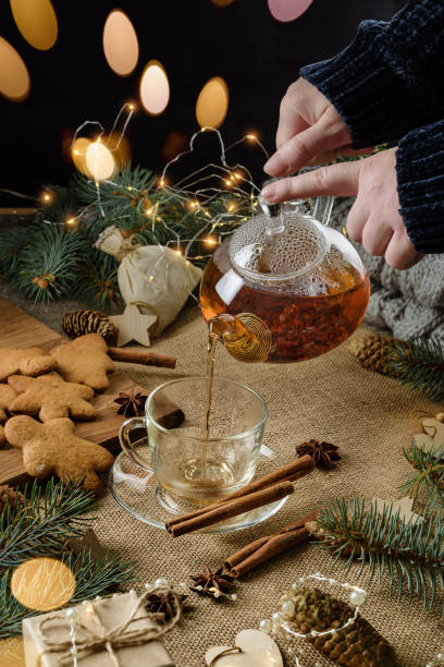 istock A woman pours tea from a glass teapot into a cup. 1285796531