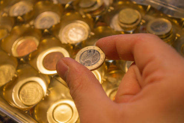 istock Man hand holds 1 euro coin from a collection 1285797275