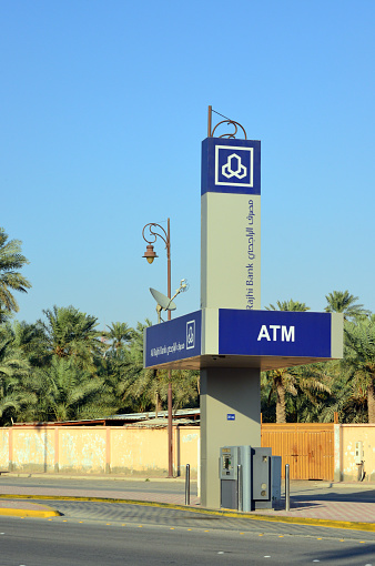 Al-Hofuf, Al-Ahsa Oasis, Al-Ahsa Governorate, Eastern Province, Saudi Arabia: Drive-up ATM / drive-through ATM on King Khalid Road - Al-Rajhi Bank - Saudis like American style convenience - date palm orchard in the background.