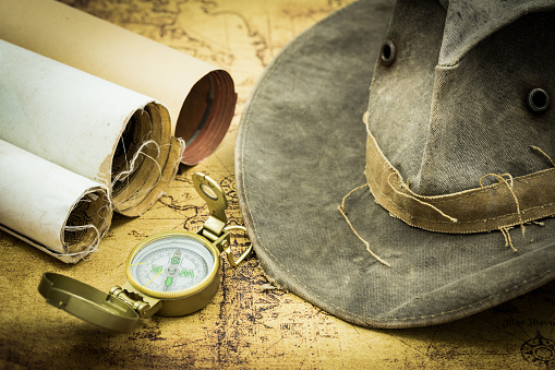Old maps with a compass. and hat. The concept of expeditions and travel, discovering the world
