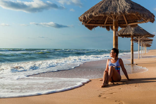 istock Woman in a swimsuit posing on the beach 1285802491