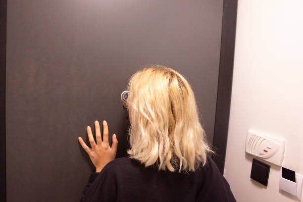 Peering through the peephole peephole, blond hair, safety, one person, door peep hole stock pictures, royalty-free photos & images