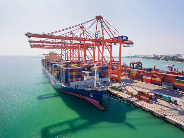 istock Front view of Container Cargo ship with working crane bridge in harbor at sunrise. Aerial view. 1285803983