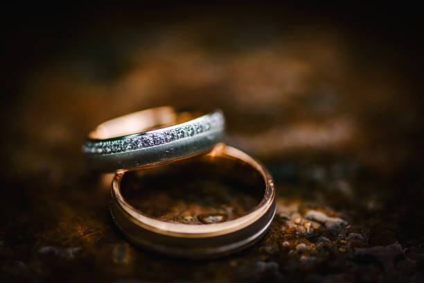 istock Wedding rings on a table with water drops on it 1285804886