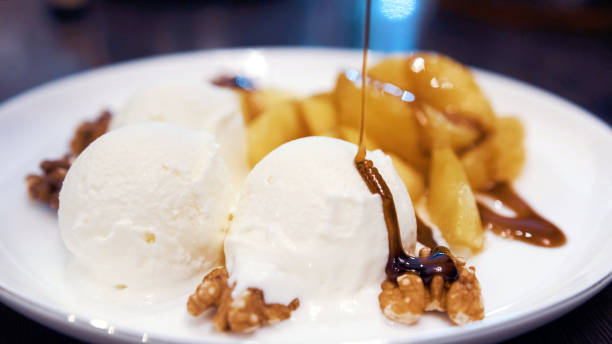 istock Vanilla icecream with fried orange and apple poured with delicious narsharab sauce. Walnut. Close up 1285805334