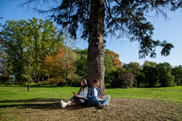 istock guy with girl with gadgets in the park 1285808896