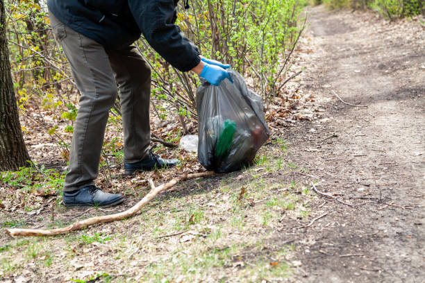 istock Man in gloves collects plastic trash in forest 1285809888