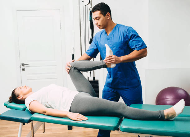 physiotherapist doing leg muscle stretching to the patient. Treatment of a woman's sciatic nerve physiotherapist doing leg muscle stretching to the patient. Treatment of a woman's sciatic nerve environmental regeneration photos stock pictures, royalty-free photos & images