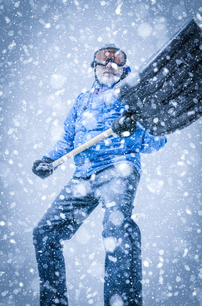 istock Man with goggles and shovel during snowstorm 1285812018