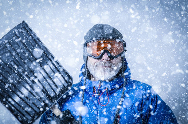 istock Man with goggles and shovel during snowstorm 1285812246