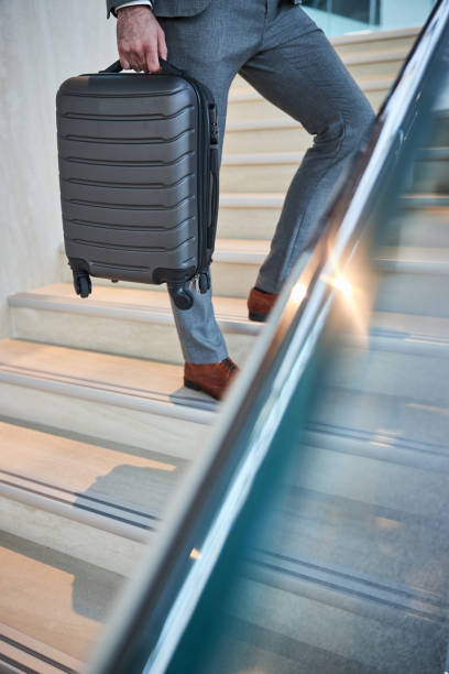 istock Person holding his case while staying near the stair rails 1285812437