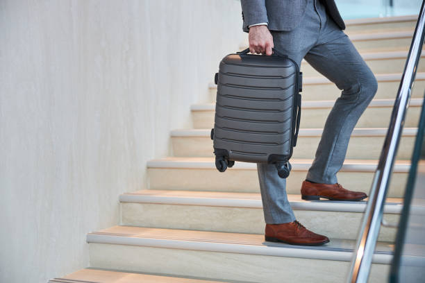 istock Male hand holding a small carry-on on a stairway 1285812448