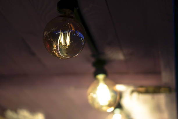 Beautiful light bulb shines in the dark. electric light at night. stock photo