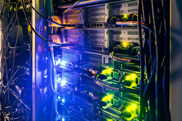 istock Data center computer equipment. There is a rack with computer hardware and cables in the dark room. Modern cloud data servers operate in the dark. 1285819224