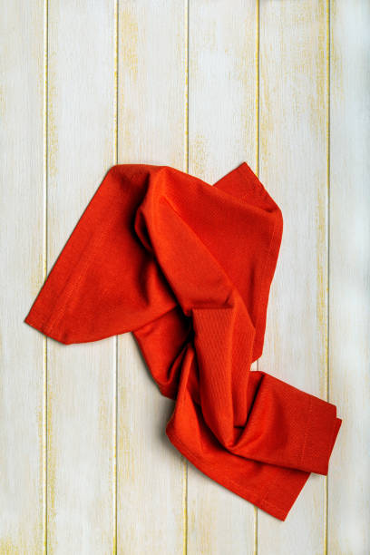 Shaped red tablecloth on a yellow wooden table.