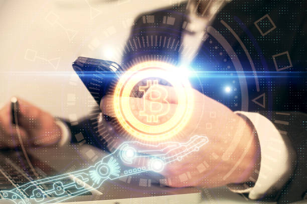istock Double exposure of man's hands holding and using a phone and crypto currency blockchain theme drawing. 1285825570