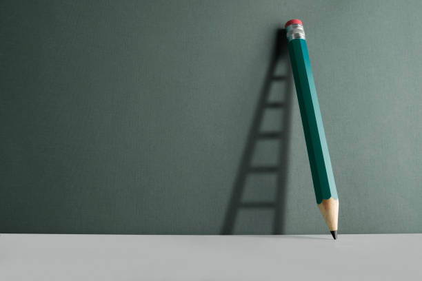 istock A pencil leaning against the wall. Ladder shade reflect on the wall. 1285825961