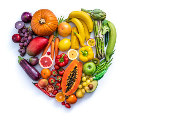verdure e frutta con forma cardiaca come concetto di salute cardiovascolare sul bianco - cucina vegetariana immagine foto e immagini stock