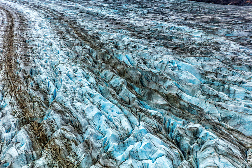 Glacier arm blue ice texture from above. Top aerial view from helicopter ride in Glacier Bay National Park, Alaska, USA. Shore excursion from cruise ship travel vacation.