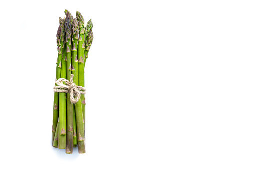 Bunch of fresh green asparagus shoots at retail market display, close up, high angle view