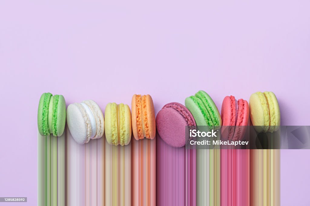 Row of colorful macarons Top view of colorful macaron biscuits in a row on pastel color block background, flat lay, pixel stretch Cookie Stock Photo
