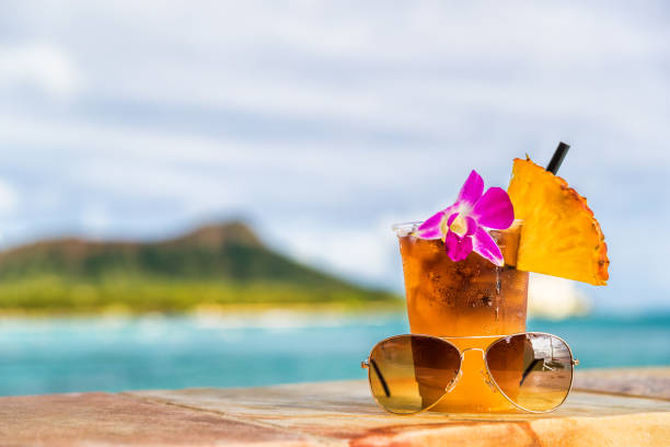 Hawaii mai tai cocktail drink on waikiki beach bar with flower, pineapple and sunglasses. View of the ocean and diamond head mountain in Honolulu, Hawaii. Summer vacation Hawaii mai tai cocktail drink on waikiki beach bar with flower, pineapple and sunglasses. View of the ocean and diamond head mountain in Honolulu, Hawaii. Summer vacation. honolulu stock pictures, royalty-free photos & images