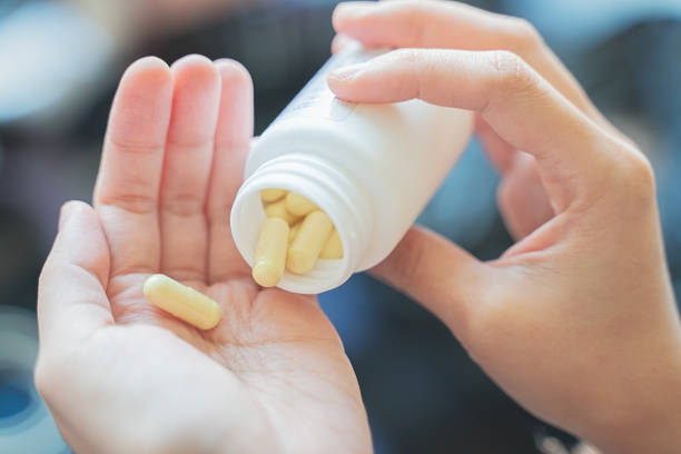 istock Taking medicines with glass of water 1285832294