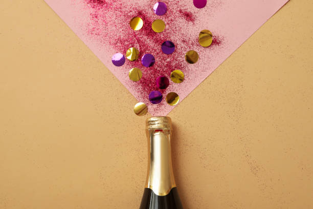 istock Bottle of champagne and glitter on two tone background 1285836399