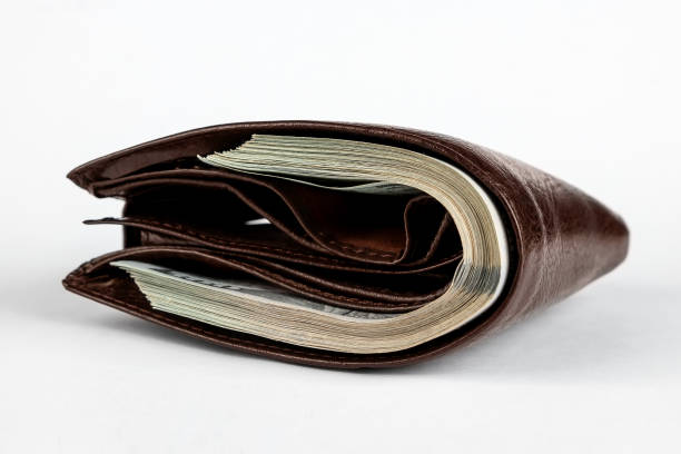 istock Brown wallet with dollars sticking out isolated on white background. 1285837135