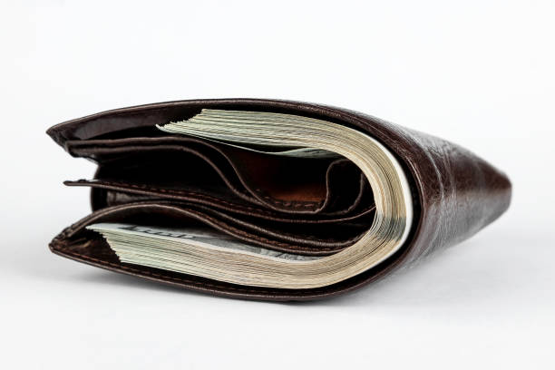 istock Brown wallet with dollars sticking out isolated on white background. 1285837136