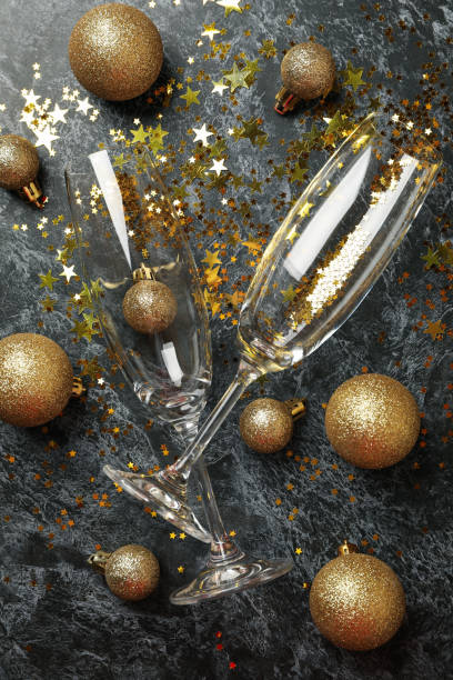 istock Champagne glasses, glitter and baubles on black smokey background 1285837481
