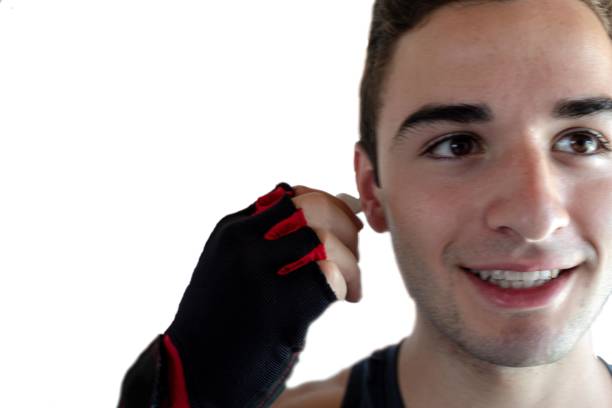 istock young man smiling putting the small bluetooth headphones on his ear to start an exercise session with copy space and white background 1285838518