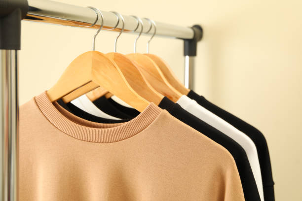 istock Hangers with stylish sweatshirts on beige background 1285838777