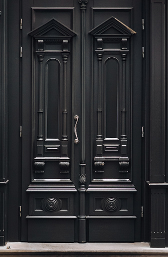 Black luxury antique wooden doors with columns, carvings and glass. Entrance to the house.