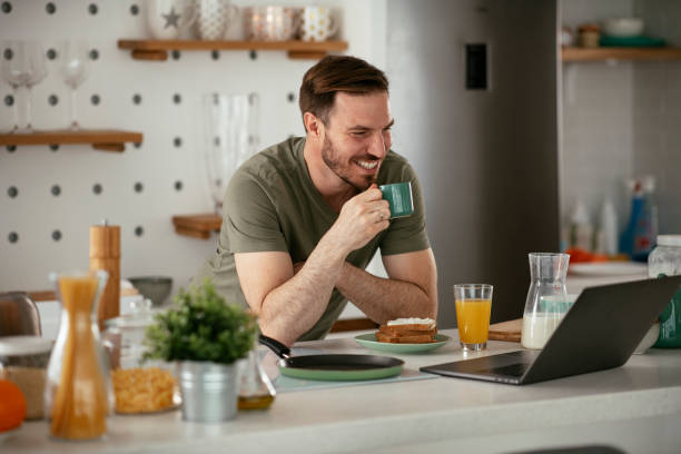 istock Young man eating breakfast and reading the news online. 1285840842