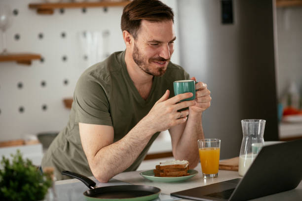 istock Young man eating breakfast and reading the news online. 1285840930