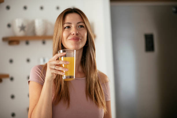 istock Beautiful woman preparing breakfast and drinking juice. 1285843999