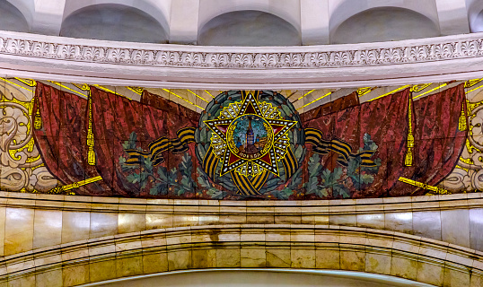 Moscow, Russia- November 4, 2018: Large fluorescent mosaic, dating from 1952, by Pavel Korin, depicting the Order of Victory surrounded by red and green banners and Georgian colors, at Komsomolskaya Metro station in Moscow