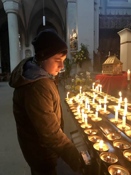 istock A boy admiring burning candles in a church. 1285845206