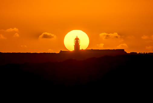 Sun behind Lighthouse of Cabo de São Vicente at sunset. Algarve, Portugal. The lighthouse is situated on the top of the Cape of St. Vincent, the Continental Europe's most South-western point