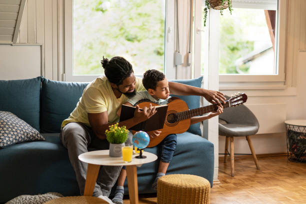istock Young boy learning to play guitar. 1285851308