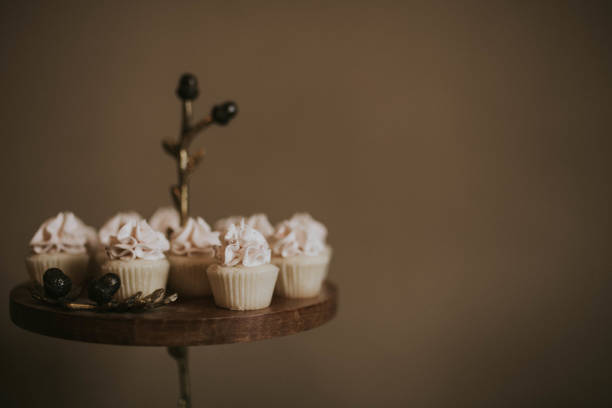 Miniature cupcakes on a brass and wood stand with lots of copy space.