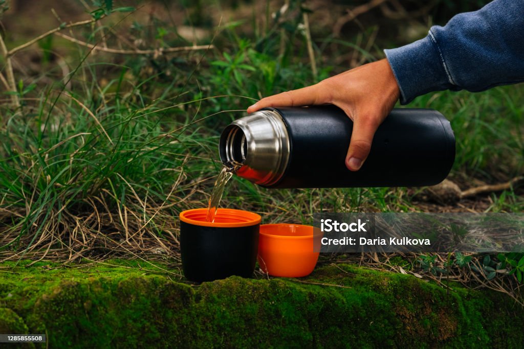Man Hand Pouring A Hot Drink In Mug From Thermos Drinking Tea During Hike  In The Woods Camping Equipment Stock Photo - Download Image Now - iStock
