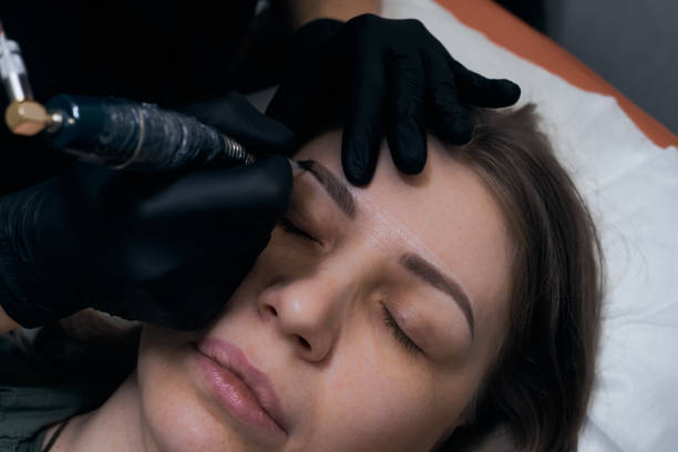 istock Permanent eyebrow makeup procedure. Eyebrow tattooing, process. The use of tools by a master for permanent eyebrow makeup. 1285857412