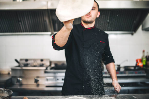 istock Male Chef preparing a pizza in the kitchen 1285857714
