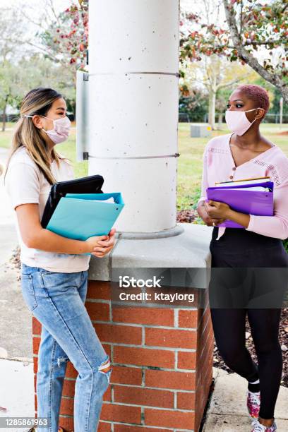 Young Adults Talk Between Classes While Wearing Protective Face Masks Stock Photo - Download Image Now