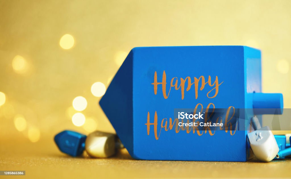 Hanukkah background with dreidel on gold and Happy Hanukkah message Hanukkah Stock Photo